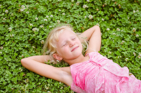 小可爱的女孩躺在草地上享受生活