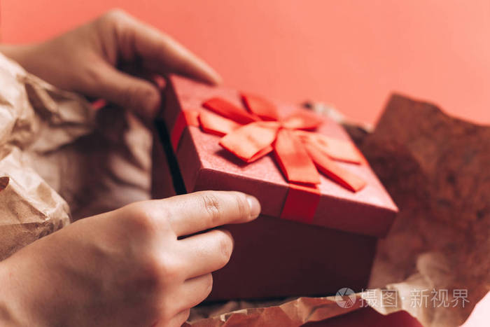 女孩收到了一个美丽的红盒子的礼物丝带和将打开它