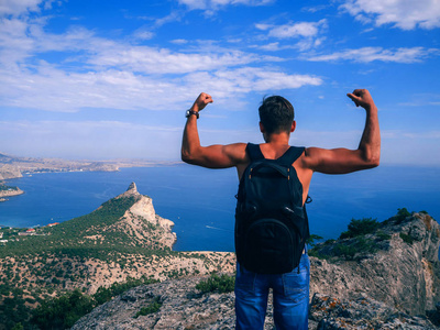 背着背包的男子旅行者站在山的悬崖边