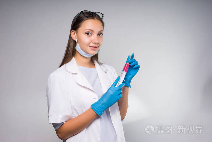 年轻护士女孩微笑, 而准备使用注射器