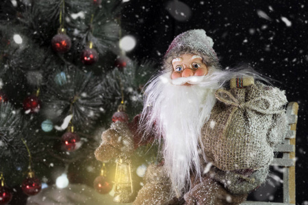 圣诞老人在外面的圣诞树上, 在下雪的时候带礼物给孩子们。圣诞和新年前夕的概念