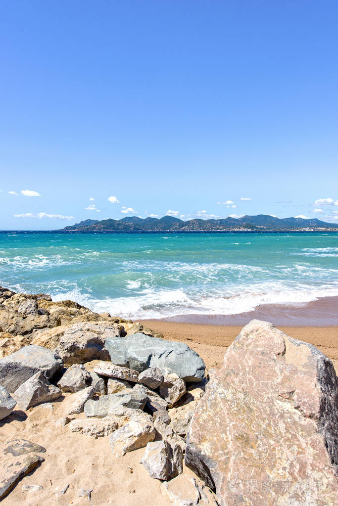 阳光明媚的景色从岩石到蓝色海和山