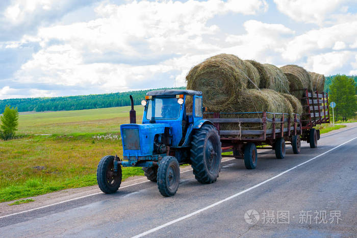 拖拉机在拖车上携带干草包