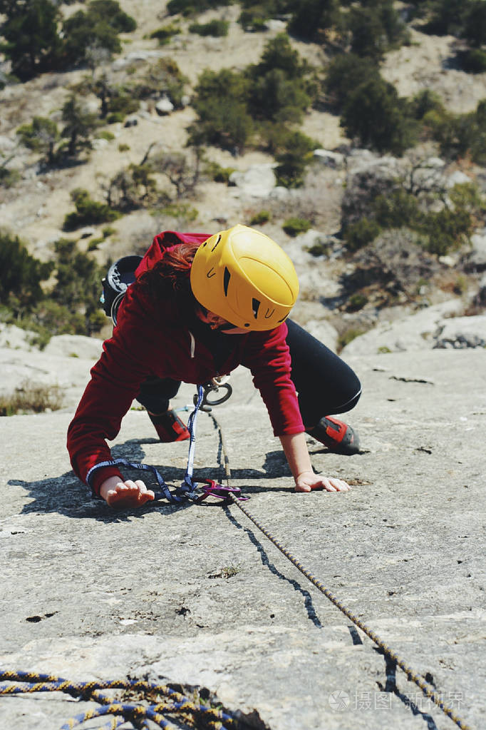 一个年轻女子用绳子从事攀岩运动
