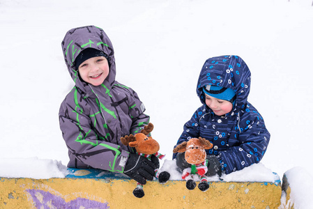 两个可爱的学龄前儿童兄弟男孩在冬天穿坐 amou