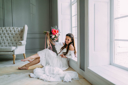 开朗，年轻的新娘举行仿古婚礼花束与牡丹全景窗口背景上。特写肖像。一束鲜花快乐的黑发女孩
