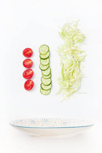 与蔬菜一起飞行的沙拉碗 西红柿黄瓜白底白菜