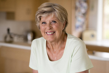 美丽和甜美的中年成熟女人在70岁左右的漂亮肖像在家厨房微笑愉快和友好