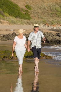 可爱的高级成熟夫妇在他们的60s 或70s 退休步行愉快和放松在海滩海边在浪漫的老龄化一起