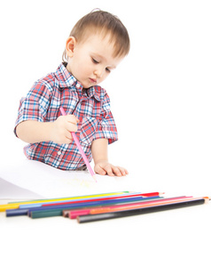 桌子旁的一个小男孩用彩色铅笔画画