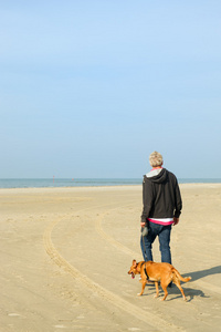 在海滩上带狗的男人