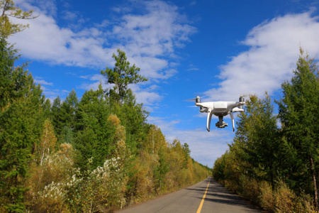 现代无人机飞行在秋天森林之上