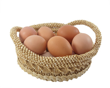 白色背景上棕色篮子里的复活节鸡蛋