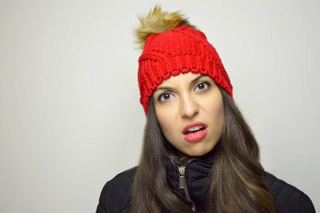 半信半疑的不可思议的女孩在灰色背景照片