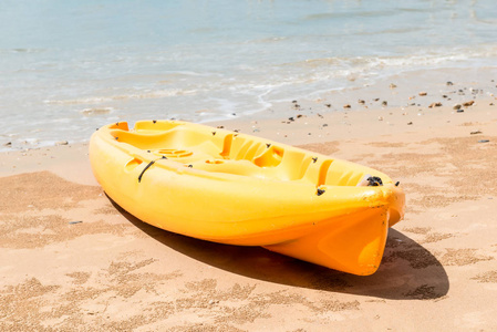 特写镜头的黄色皮划艇在水的边缘在沙地中非金融合作