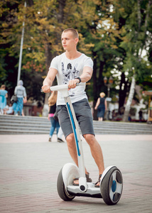 年轻的白种人骑着赛格威在城市公园