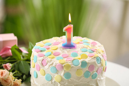 用蜡烛为模糊背景上的第一个生日蛋糕