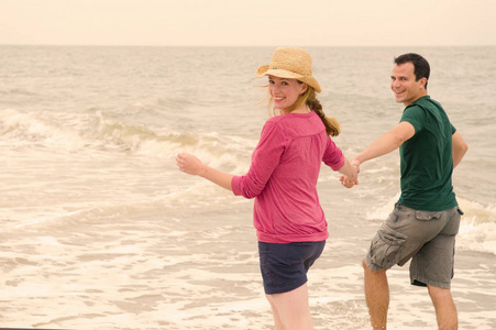快乐的成年白种夫妇在海上奔跑