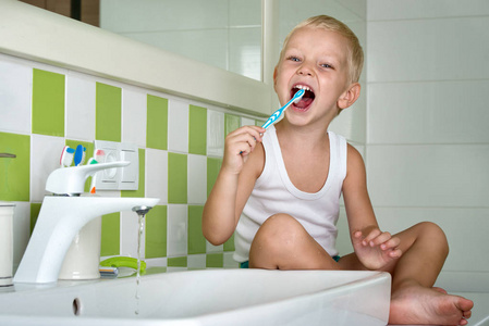 小男孩在浴室里刷牙。开始新的一天