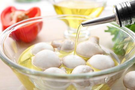 用生蘑菇将橄榄油倒入碗中