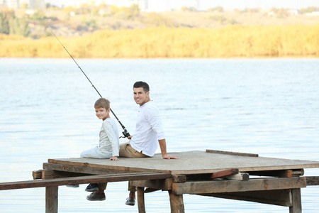 父亲和他的儿子从码头上河钓鱼图片