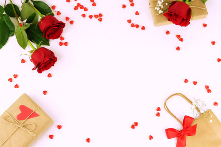 女性假日书桌, 桌, 工作区与红色玫瑰, 心脏, 礼物和一个包裹在白色背景。平躺, 顶部视图. 复制空间