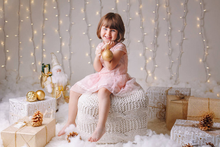 白色白种女孩的画像与蓝色眼睛坐与玩具庆祝圣诞节或新年假日