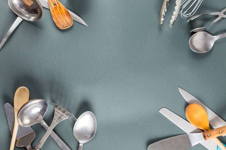 在灰色的纸张背景上使用带划痕的家用厨具