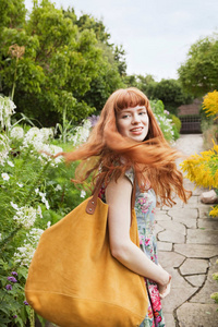 年轻美丽的白种人红头发的妇女回头看公园照片