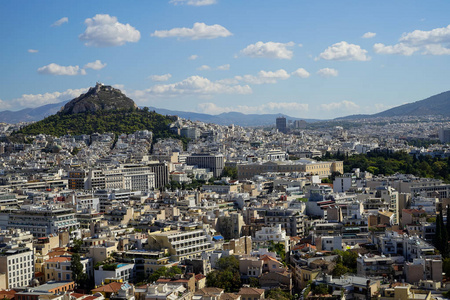 从卫城看雅典城市建筑, 山 Lycabettus, 高山, 蓝天和漂浮的白云背景