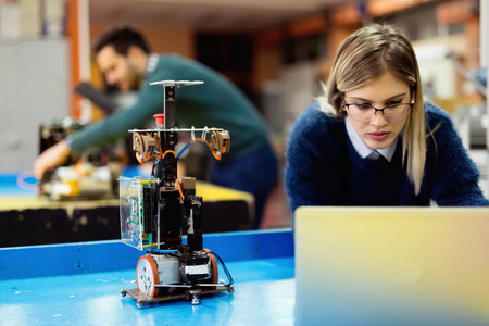 车间工程师工程师在车间测试他的机器人照片