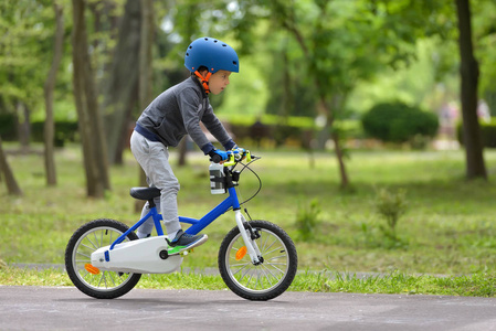 快乐的孩子男孩美丽的秋天天用一辆自行车的春天公园里开心的 5 年。活跃的孩子戴着自行车头盔