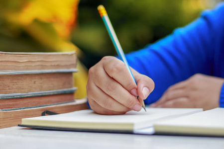 女性手与春天衬衣写东西用铅笔照片