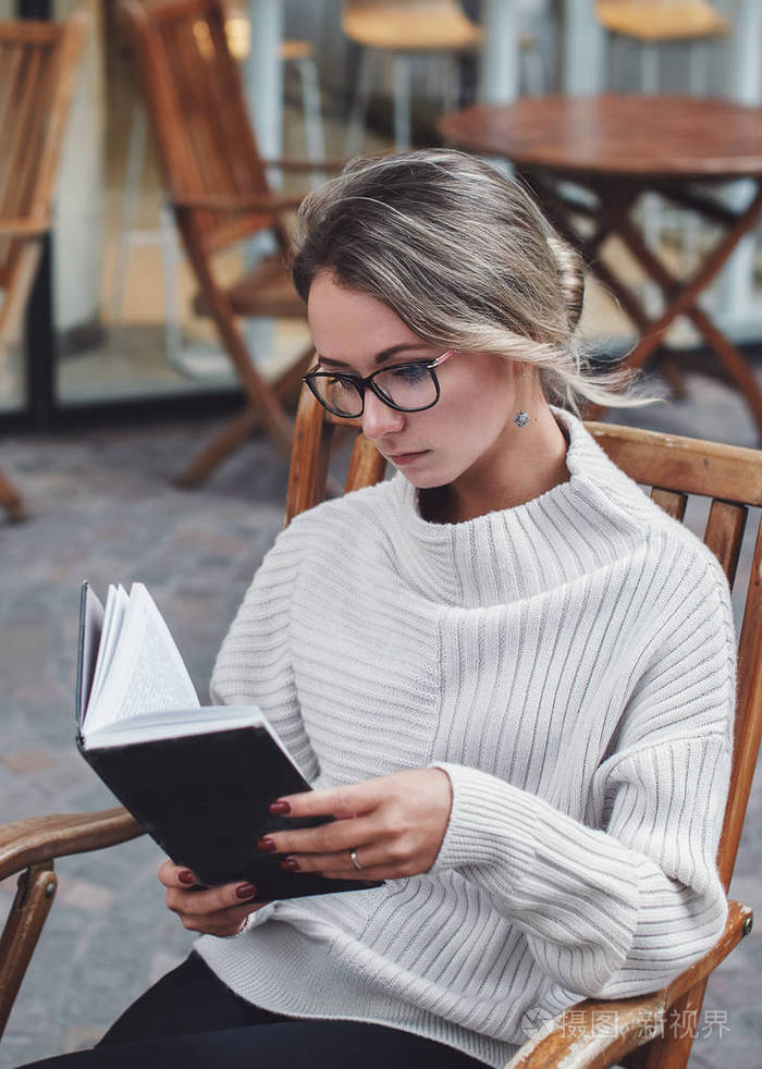 女人在户外看书的画像