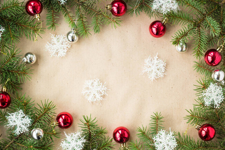 节日的圣诞边界与红色和银色的球冷杉树枝和雪花在质朴的米色背景