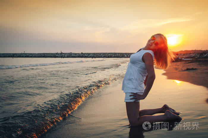 傍晚海边海滩上的金发女郎
