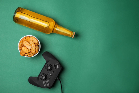 色彩背景下的视频游戏控制器啤酒和小吃组合