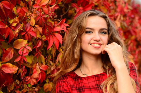 户外时尚照片的年轻美女包围着秋天的落叶