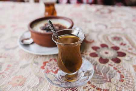 在盘子里烘烤的米饭甜点。咖啡馆里有一杯香浓的热茶。对一杯茶的选择性关注