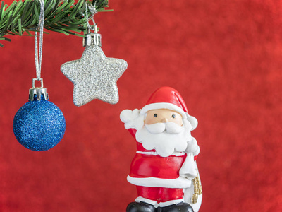 圣诞老人玩偶站立在蓝色圣诞节球和银色星之下