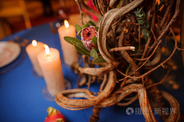 表装饰制成的花，干的树枝和蜡烛
