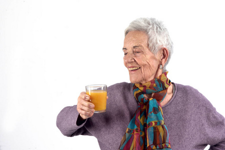 高级妇女喝果汁在白色背景照片