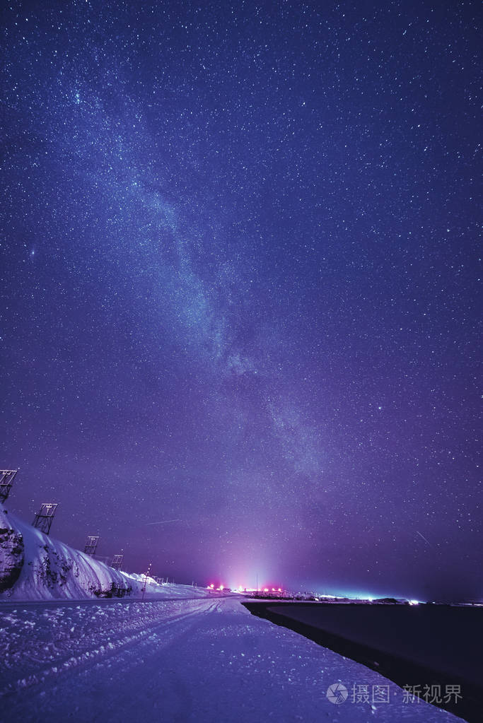 与多彩银河系和黄灯在山的夜景观满天星斗的天空在夏天的小山美丽的