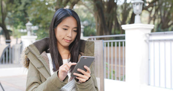 妇女检查智能手机在城市