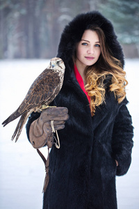 美丽的女人和猎鹰在冬天