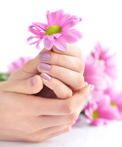 粉红色的指甲，指甲上与粉红色的花朵，白色背景上一个女人的手
