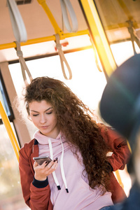 女孩在公交车中使用智能手机