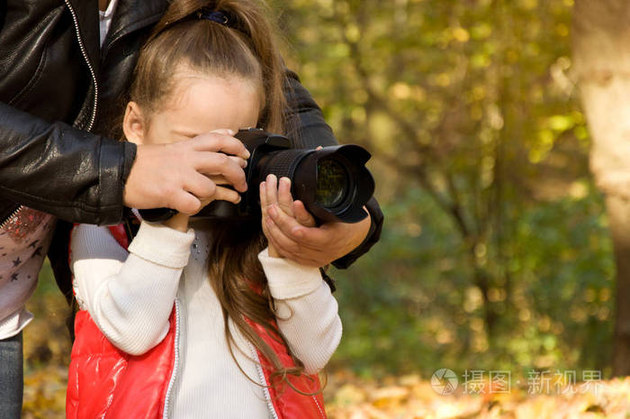 小女孩拿着照相机拍张照片业余爱好