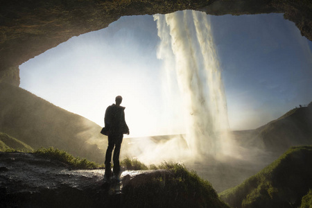 游客站在 Seljalandsfoss 在冰岛南部，Seljalandsfoss，冰岛最著名的瀑布之一