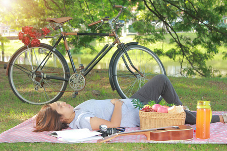 妇女与睡眠在公园团结放松概念